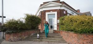 Nurse with a dog on steps outside Rowan Vets in Blackpool